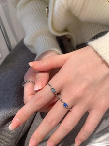 Macro de la bague chaîne en argent ornée de zircons bleus taillés en émeraude