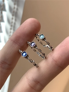 Détail de trois bagues en argent avec zircons carrés et texture de chaîne torsadée