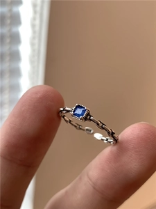 Détail d'une bague en argent S925 avec zircon bleu taille émeraude et anneau tressé