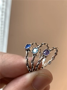 Gros plan sur bagues en argent S925 avec pierres carrées bleues et violettes