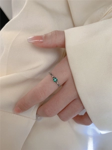 Vue détaillée d'une bague chaîne en argent avec zircon émeraude carré sur le doigt