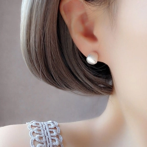 Minimalist brushed silver teardrop stud earrings worn by a model in a modern style