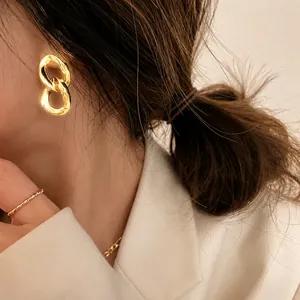Elegant gold chain link earrings worn by a model showcasing a luxury metallic design