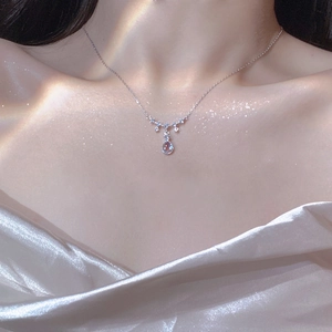 Close-up of teardrop moonstone pendant on silver necklace worn on neck over silk