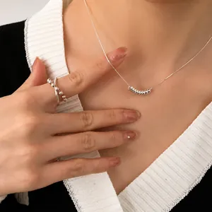 Conjunto de collar y anillo con cuentas plateadas en un estilo minimalista francés