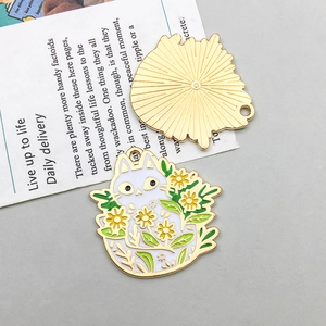 Detail eines Emaille-Katzenanhängers mit floralem Design und goldener Metallrückseite