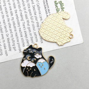Detalle del colgante de gato esmaltado con diseño de noche estrellada y reverso dorado