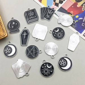 Detailed view of Gothic style black enamel charms including crystal balls and magic books