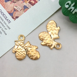 Detail von vergoldeten Weihnachtshandschuh-Anhängern mit Schleifenrelief für DIY-Schmuck