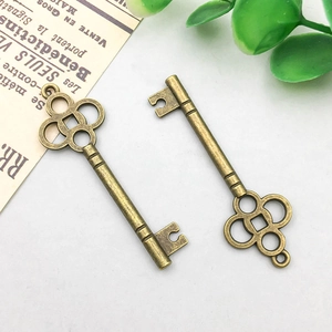 Detail of vintage bronze key pendants with floral openwork for DIY jewelry making