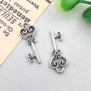 Detail of vintage antique silver alloy key pendants with heart and scroll patterns