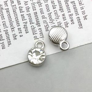 Macro shot showing front rhinestone detail and textured back of silver DIY pendants