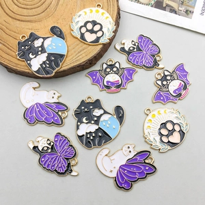 Foto macro de colgantes de gato en esmalte de colores con alas de murciélago para joyería DIY