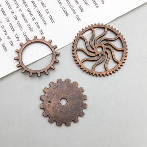 Close-up of three vintage bronze steampunk gear pendants with intricate metallic textures