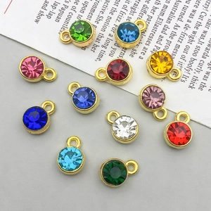 Flat lay of vintage gold alloy pendants with twelve colorful sparkling rhinestones