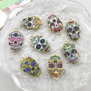 Makroansicht bunter Emaille-Totenkopf-Anhänger mit goldenem Metallrand für DIY-Schmuck