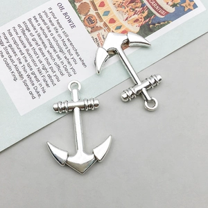 Détail de deux pendentifs ancre marine argentés pour la création de bijoux DIY sur papier