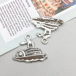 Détails de charms paquebot en argent vintage montrant le relief et la texture