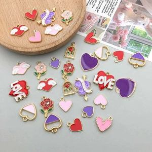 Flat lay of colorful enamel heart and rose charms with LOVE engraving for DIY jewelry
