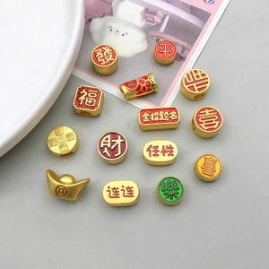 Macro shot of traditional Chinese New Year gold charms with red enamel and auspicious characters