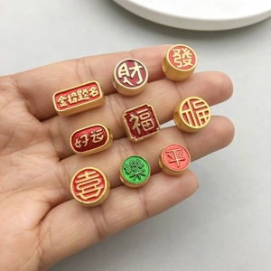 Golden Chinese New Year charms with red enamel and auspicious fortune characters