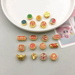Macro view of Chinese New Year charms with red enamel and lucky gold characters