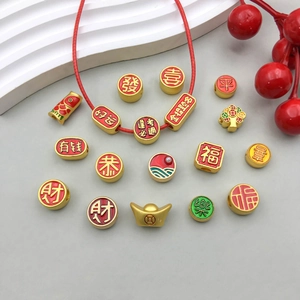 Close-up of gold-plated Chinese New Year charms with red enamel and lucky characters