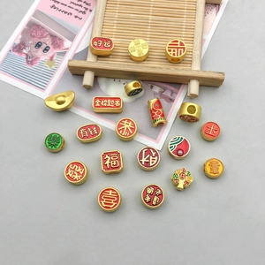 Detailed view of DIY golden Chinese New Year charms with red enamel lucky characters