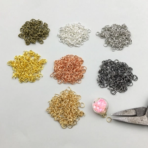 Vista piana di anellini di metallo colorati e pinze per accessori gioielli DIY