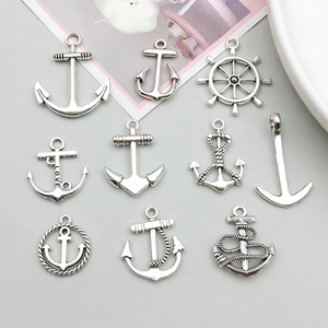 Detailed view of antique silver nautical anchor and helm pendants for DIY jewelry
