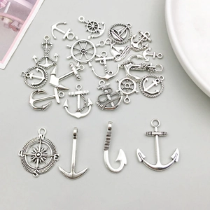 Detailed collection of antique silver nautical charms including anchors and sailboats for DIY