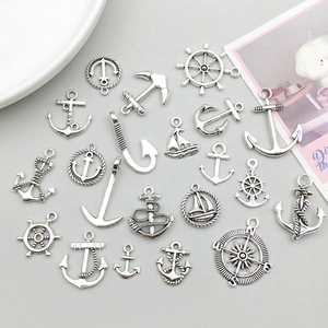Detailed view of antique silver nautical charms including anchor and sailboat for DIY crafts