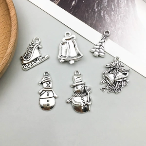 Detail of vintage silver Christmas charms including sleigh, bells and snowmen for DIY jewelry