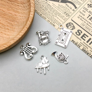 Set of vintage silver music charms including drum kit, piano, and horn for DIY jewelry