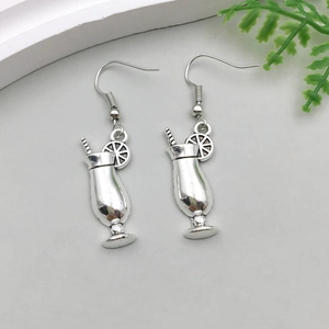 Close-up of cocktail glass earrings with lemon slices and straws in antique silver finish