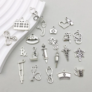 Detailed macro view of vintage silver medical charms like stethoscopes and syringes