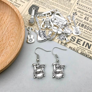 Macro shot of antique silver music instrument charms including guitar and microphone