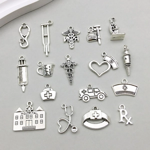 Detailed close-up of antique silver medical charms including stethoscope and syringe