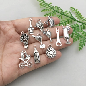 Antique silver wine themed alloy charms held in hand for jewelry making DIY