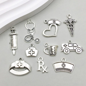 Detailed set of 10 antique silver medical charms including stethoscope and syringe