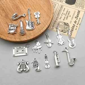 Macro detail of antique silver musical instrument charms for DIY jewelry making