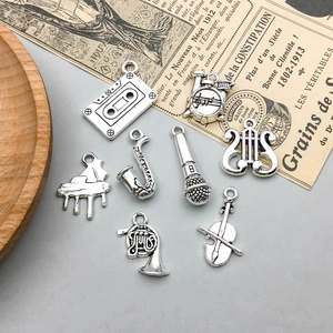 Macro detail of eight antique silver musical instrument charms including guitar and violin