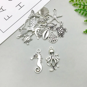 Macro detail of various antique silver sea life charms including seahorses and dolphins