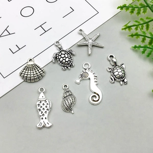 Detailed view of assorted antique silver ocean charms like seahorses and starfish for DIY crafts