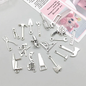 Makroaufnahme der antiken silbernen Miniatur-Werkzeuganhänger für DIY-Schmuck