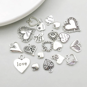 Vue détaillée de divers pendentifs cœurs en argent antique avec gravures Love et Best Friend