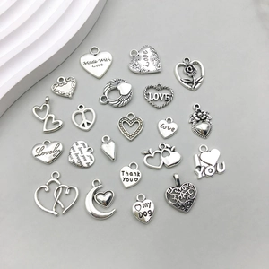 Macro shot of assorted vintage silver alloy heart pendants with engraved love messages