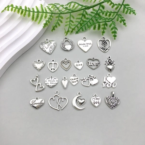 Detailed flat lay of 23 antique silver heart charms for DIY jewelry making