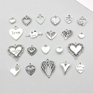 Vue macro de pendentifs cœur en alliage d'argent vintage avec divers motifs et gravures
