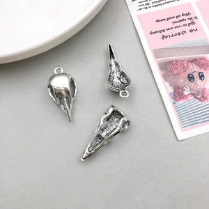 Detailed view of three antique silver crow skull pendants with gothic oxidized finish